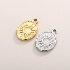 Macro detail of oval sun and moon pendants in gold and silver stainless steel finish