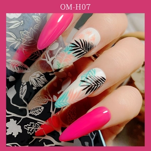 Macro shot of tropical palm leaf nail art stamps and polished pink manicure finish