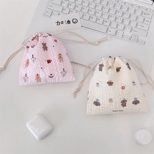 Close-up of cute cartoon drawstring pouches with textured ripple fabric and bear patterns
