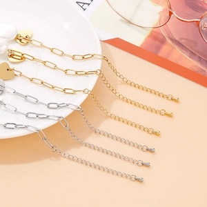 Bracelet doré à breloques cœur et coquillage avec perles sur un plateau de style