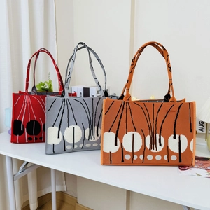 Detailed trio of red, grey, and orange knitted tote bags with abstract dot patterns