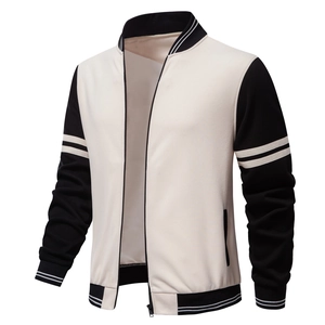 Detail of a black and cream varsity jacket showing striped ribbing and a metal zipper