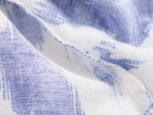 Detailed close-up of blue and white floral fabric with precise stitching and hem finish