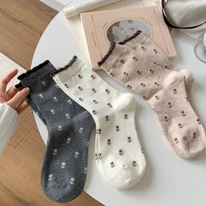 Chaussettes vintage en coton à motif tulipe avec bords volantés sur une table