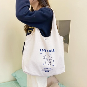 Détail du sac cabas en toile blanche avec imprimé chien bleu et bouton pression métallique