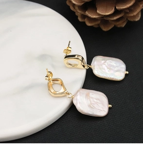Detail of square gold setting holding an irregular natural pink freshwater pearl earring