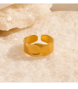 Macro shot of gold-plated irregular hammered texture ring on a white crystal stone background