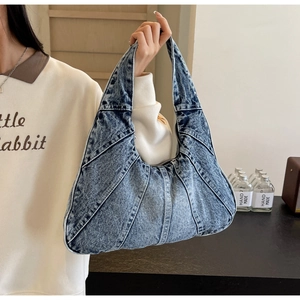 Détail du sac hobo en jean bleu avec coutures contrastées et texture souple décontractée
