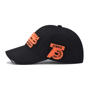 Detail of black cotton baseball cap with orange embroidery and distressed brim edge
