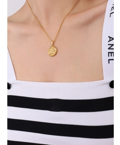 Close-up of 18k gold-plated titanium wing pendant necklace on a model's neck