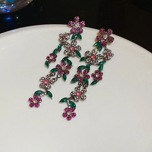 Detail of vintage flower tassel earrings with pink crystals and green leaf stones