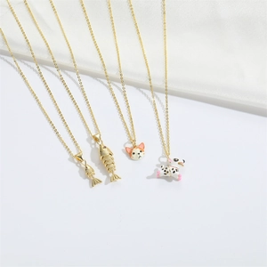 Minimalist gold necklaces with cute enamel cat, dog and fish charms on white silk