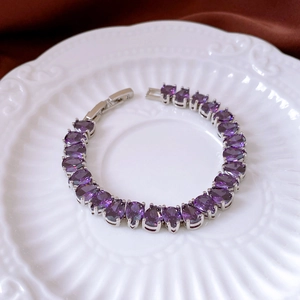 Detail of silver bracelet with drop-shaped purple crystals and secure folding clasp