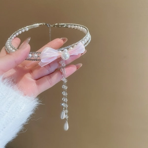 Close-up of double-layer choker with pink bow, rhinestones, and hanging pearl tassels