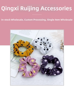 Detailed view of four colorful polka dot scrunchies in yellow, white, lilac and navy blue