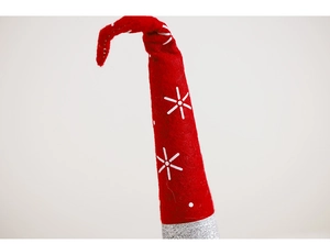 Close-up of red felt Christmas gnome hat with white snowflake patterns and texture