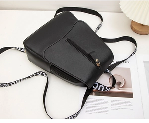 Detail view of black PU leather backpack featuring anti-theft back zipper and logo straps