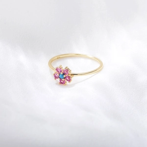 Detailed close-up of floral S925 silver ring with pink gems and turquoise center