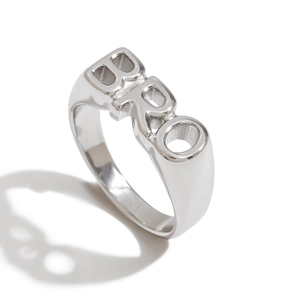 Detailweergave van zilveren roestvrijstalen ring met opengewerkt BRO-letterontwerp