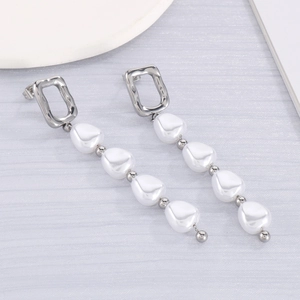 Vue détaillée de boucles d'oreilles argentées avec perles baroques et design géométrique