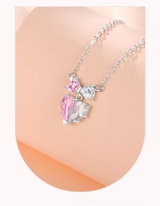Macro detail of 925 silver necklace with pink bow-shaped zircon and crystal pendants