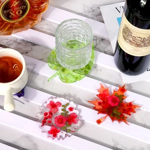 Handmade resin coasters with real dried flowers in leaf and round shapes on marble surface