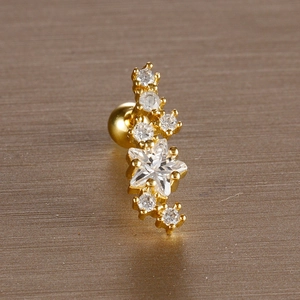 Macro shot of gold star helix earring with clear zircon and screw ball back