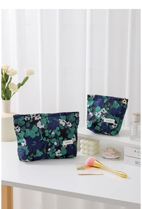Detail of floral jacquard toiletry bags with flower-shaped zippers and woven logo tags