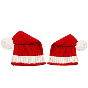 Matching set of red knitted Christmas pom-pom hats for parent and child on white background