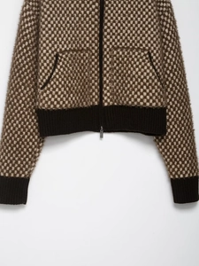 Detail of checkered knit bomber jacket with brown and beige texture and ribbed cuffs