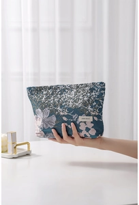 Close-up of jacquard cosmetic bag with floral patterns and branded fabric label