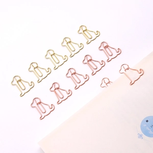 Dog shaped metal paper clips in gold and rose gold used as creative bookmarks