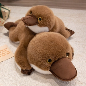 Realistic plush platypus toys with soft brown faux fur in a cozy home setting