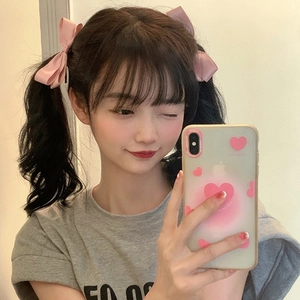 Pink ribbon bow hair clip styled for women on a stylish aesthetic mirror selfie background
