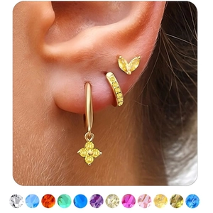 Detailed view of gold plated earrings set with yellow stones and a colorful gem chart