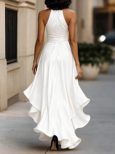 Detail of white satin backless halter dress showing layered ruffle hem and glossy fabric