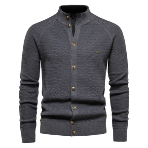 Close-up of grey men's knit cardigan showing waffle texture and dark brown buttons