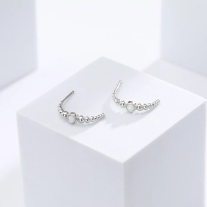 Detail of S925 silver stud earrings featuring white opal stones and beaded edge texture