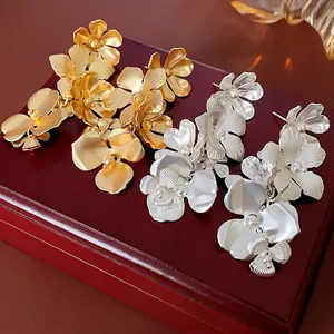 Boucles d'oreilles fleurs dorées et argentées avec texture mate et perles sur bois