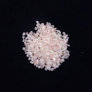 Macro view of irregular pink rose quartz crystals on a high-contrast black background