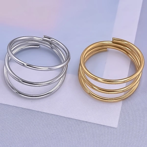 Detail of minimalist triple-layered gold and silver stainless steel rings with open design