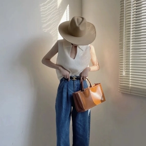 Femme élégante portant un chapeau fedora en laine camel et un haut en tricot blanc