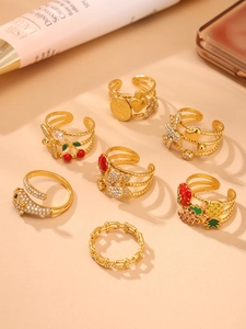 Close-up of gold-plated rings with colorful enamel fruit and floral details