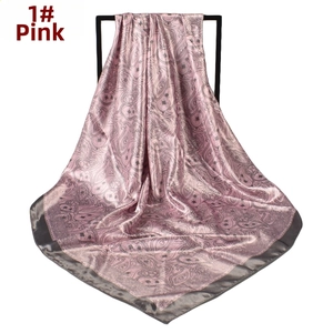 Macro detail of pink paisley satin scarf with grey border on display stand