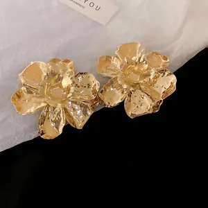 Statement gold flower earrings with textured metallic petals in a 3D floral design