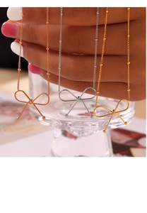 Close-up of minimalist bow pendant necklaces in gold, silver, and rose gold finishes