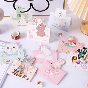 Flat lay of cartoon animal gift cards featuring bears, rabbits and unicorns with greetings