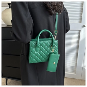 Detail of green quilted crossbody bag with matching coin purse and golden hardware