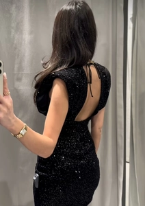 Détail du dos nu sexy et de la fermeture à lacets de la robe courte à paillettes noires