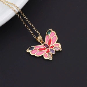 Close-up of golden butterfly necklace with pink enamel and multicolor gemstones